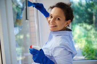 多民族家庭主妇洗湿巾窗口洗涤剂喷雾玻璃清洁刮板幸福的做家务