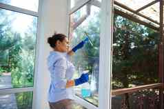 多民族年轻的女人家庭主妇女仆清洁窗户执行家庭家务春天清洁管家