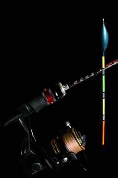 钓鱼杆卷色彩斑斓的钓鱼浮动黑色的背景
