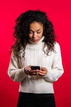 女孩非洲式发型头发智能手机冲浪互联网玩游戏红色的工作室背景现代技术应用程序社会网络