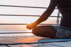 集中女孩黑色的练习瑜伽冥想木海滨女人莲花构成伸展运动实践健康的生活方式概念复制空间