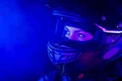 肖像自信骑摩托车的人女人关闭摩托车头盔年轻的司机骑摩托车的人蓝色的霓虹灯光晚上复制空间