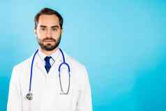 肖像年轻的英俊的男人。专业医疗白色外套孤立的蓝色的工作室背景医生胡子听诊器复制空间