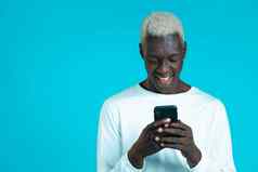 英俊的非洲男人。智能手机蓝色的工作室墙现代技术应用程序社会网络