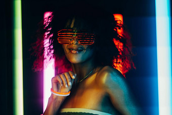 <strong>赛博朋克风</strong>格肖像迷人的非洲女人聚会，派对发光的色彩斑斓的光夜总会未来主义的服装霓虹灯眼镜少年变焦器z-generation