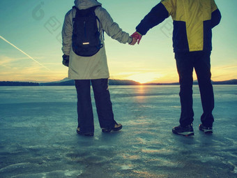旅游夫妇支出时间在户外冻湖看不断上升的太阳地平线
