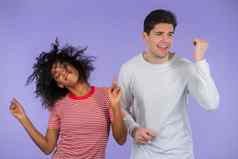 年轻的非洲美国女人白色男人。跳舞孤立的紫色的背景聚会，派对幸福音乐跨种族夫妇概念