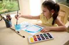可爱的学龄前儿童女孩洗画笔玻璃水绘画图片水彩油漆