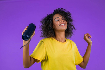 混合比赛女人听音乐无线可移植的演讲者现代声音系统非洲夫人跳舞享受紫色的工作室背景移动节奏音乐