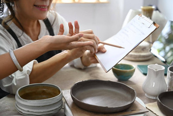 女陶器商店老板检查购买订单准备<strong>产品</strong>交付做<strong>服装</strong>的人在线销售电子商务概念