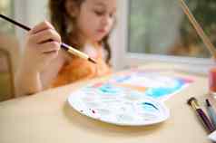 焦点白色调色板混合油漆模糊女孩绘画水彩画油漆孩子爱好