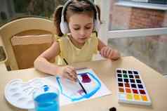可爱的学龄前儿童女孩耳机艺术家画图片水彩油漆爱好艺术主类