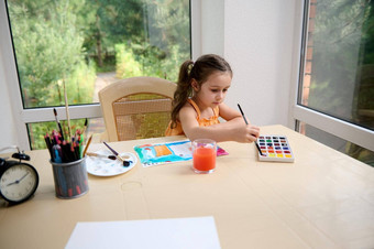 高加索人孩子小学年龄女孩坐着表格绘<strong>画图片水</strong>彩画画笔