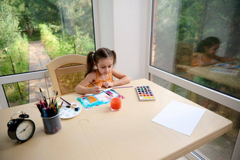 前视图可爱的孩子小学年龄女孩坐着表格绘画图片水彩画画笔