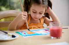 集中聪明的学龄前儿童女孩绘画图片水彩画画笔