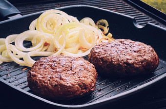 烹饪剁碎牛肉汉堡投铁烧烤长柄平底煎锅在户外红色的肉煎锅烧烤食物花园英语农村生活