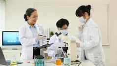 高级女主管年轻的生物技术专家科学家们进行实验实验室