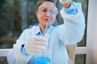 焦点实验室吸管手模糊女人科学家医疗生物学家移液蓝色的液体瓶