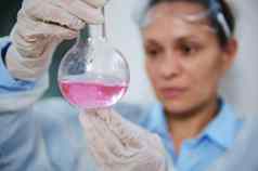 焦点实验室玻璃瓶粉红色的化学流体物质手模糊女人科学家化学家