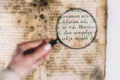 女人研究员探讨了古董书放大镜科学翻译文学调查手稿古老的作品