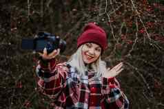 微笑旅行博主女人使视频博客视频博客相机自然森林背景影响者说话相机微笑