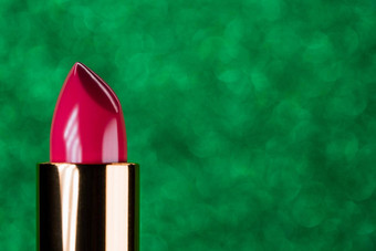 粉红色的口红不断上升的容器闪亮的绿色背景展示广告美品牌概念时尚化妆品复制空间