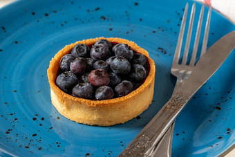 新鲜烤蓝莓蛋挞蓝色的瓷板