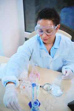 前视图女化学家科学家工作实验室实验室玻璃器皿化学物质表格