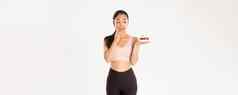 活跃的生活方式健身幸福概念可爱的浅黑肤色的女人亚洲女孩运动员诱人的吃美味的甜蜜的蛋糕饮食身体重量卡路里白色背景