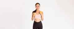 体育运动幸福活跃的生活方式概念肖像微笑健康的苗条的亚洲女孩建议吃健康的食物早餐获得能源锻炼持有新鲜的汁橙色