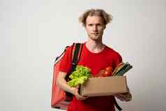 交付员工红色的t恤工作快递服务商店餐厅首页持有棕色（的）工艺纸外卖食物盒子蔬菜