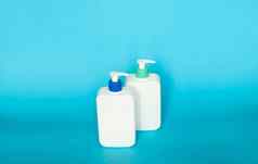 白色化妆品塑料瓶黑色的泵自动售货机蓝色的背景液体容器过来这里乳液奶油洗发水浴泡沫