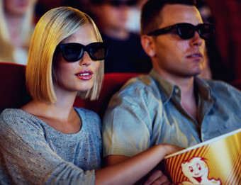 夫妇电影电影男人。女人坐着吃爆米花穿眼镜人的关系看电影剧院室内娱乐零食