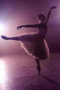 芭蕾舞舞者图图执行跳阶段芭蕾舞女演员实践地板上黑暗工作室烟紫罗兰色的光