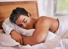 休息恢复好质量睡眠年轻的男人。睡觉和平床上