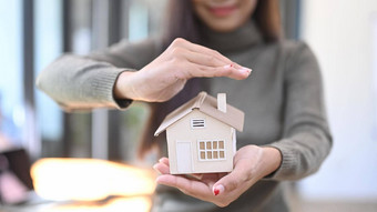微笑女人持有小房子模型真正的房地产财产保险概念