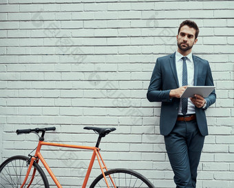 <strong>方便</strong>心英俊的年轻的商人数字平板电脑站与自行车在户外