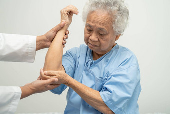 亚洲高级上了年纪的夫人女人病人感觉疼痛肘床上护理医院病房健康的强大的医疗概念