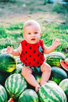 快乐婴儿男孩坐着西瓜场花园快乐婴儿孩子微笑相机孩子水果在户外健康的生活方式概念