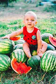 快乐婴儿男孩坐着西瓜场花园快乐婴儿孩子微笑相机孩子水果在户外健康的生活方式概念