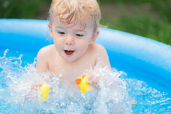 可爱的孩子洗澡鸭蓝色的街池院子里肖像快乐的蹒跚学步的婴儿孩子笑着说<strong>溅水</strong>微笑概念健康的生活方式家庭休闲夏天