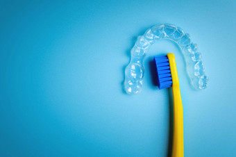 看不见的塑料对准器纠正牙齿伸直牙齿谎言蓝色的背景牙刷