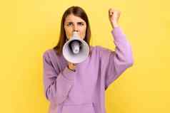 女人持有扩音器口大声说话尖叫使公告提高了手臂