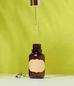 棕色（的）玻璃瓶化妆品产品吸管绿色背景容器油