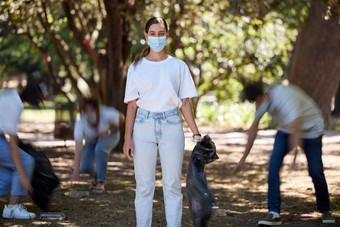 志愿者科维德清洁社区集团工作在户外肖像年轻的女工人自然森林清洁塑料垃圾绿色未来