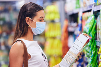 女人阅读食物盒子信息列表杂货店商店商店超市时尚的年轻的女购物科维德流感大流行面具有机新鲜的健康的成分