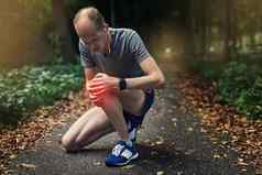 哎哟伤害了跑步者经历疼痛受伤的膝盖慢跑
