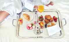 调用早餐高角拍摄认不出来女人享受健康的早餐酒店床上