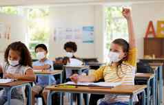 穿脸面具保护科维德学习类回答教育问题研究学生教室女孩坐着桌子上提高手流感大流行