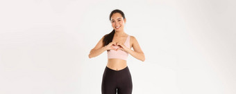 体育运动幸福活跃的生活方式概念微笑亚洲女人运动服女运动员显示心手势享受锻炼最喜欢的健身房产品爱白色背景